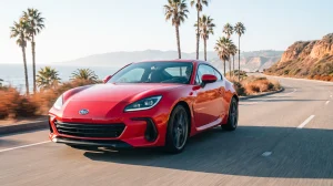 Red sports car with clear bra paint protection film driving a San Diego coastal highway