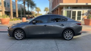 Grey sedan with fresh dark window tint parked on a sunny San Diego street